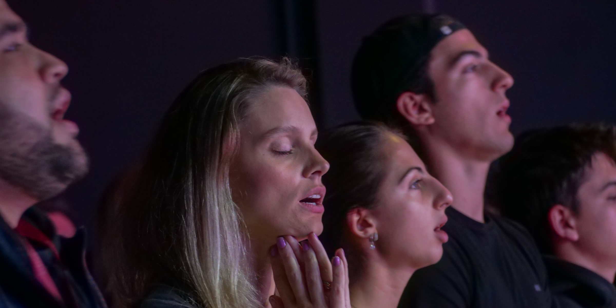 Pessoas da C3 Curitiba cantando em adoração durante o culto de domingo.