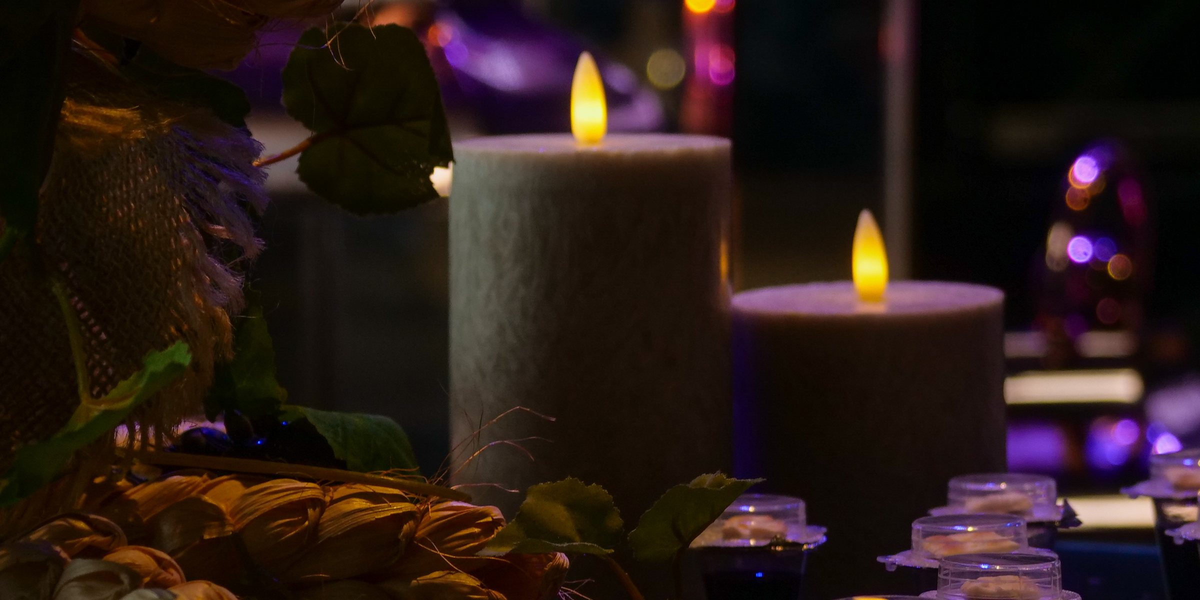Cálices da Santa Ceia dispostos na mesa, com velas acesas ao fundo.